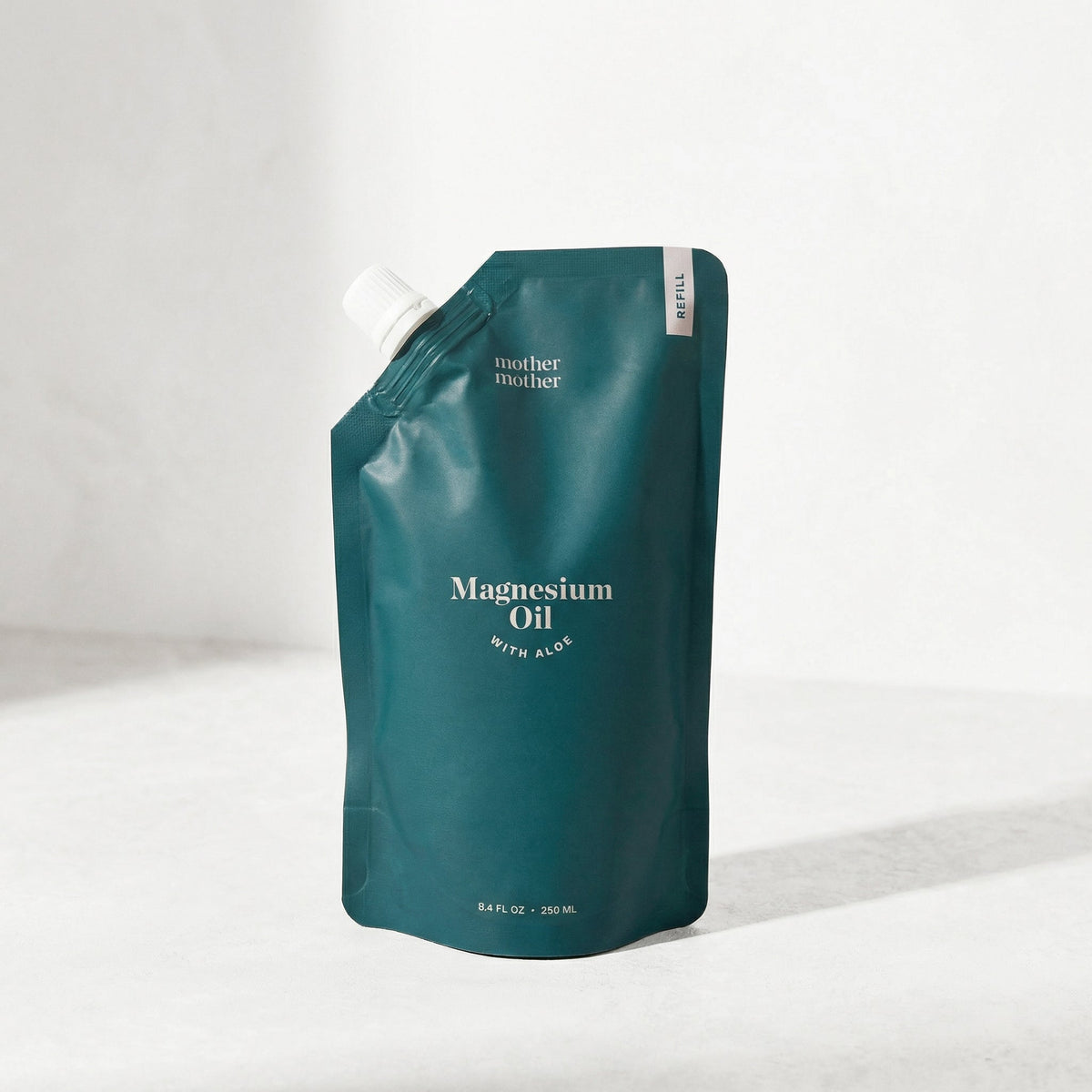 Teal pouch of magnesium oil with aloe on a white background